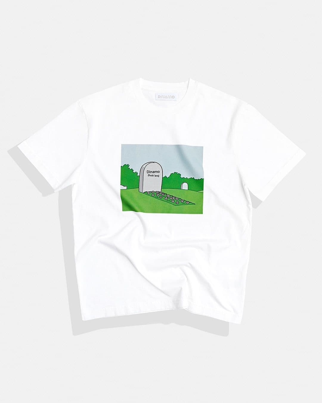 White T-shirt featuring a cartoon-style graphic of a graveyard with a tombstone labeled "Dreams" against a green landscape.