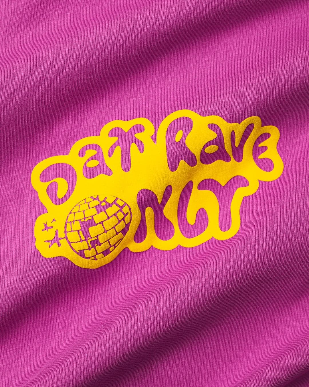 Bright pink fabric with a yellow graphic of a disco ball and the words "Day Rave Only" in bold, playful lettering.
