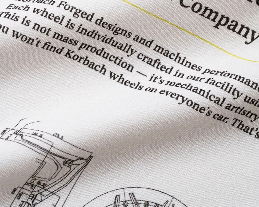 Close-up of a fabric with printed text and technical drawings, featuring phrases about craftsmanship and mechanical artistry.