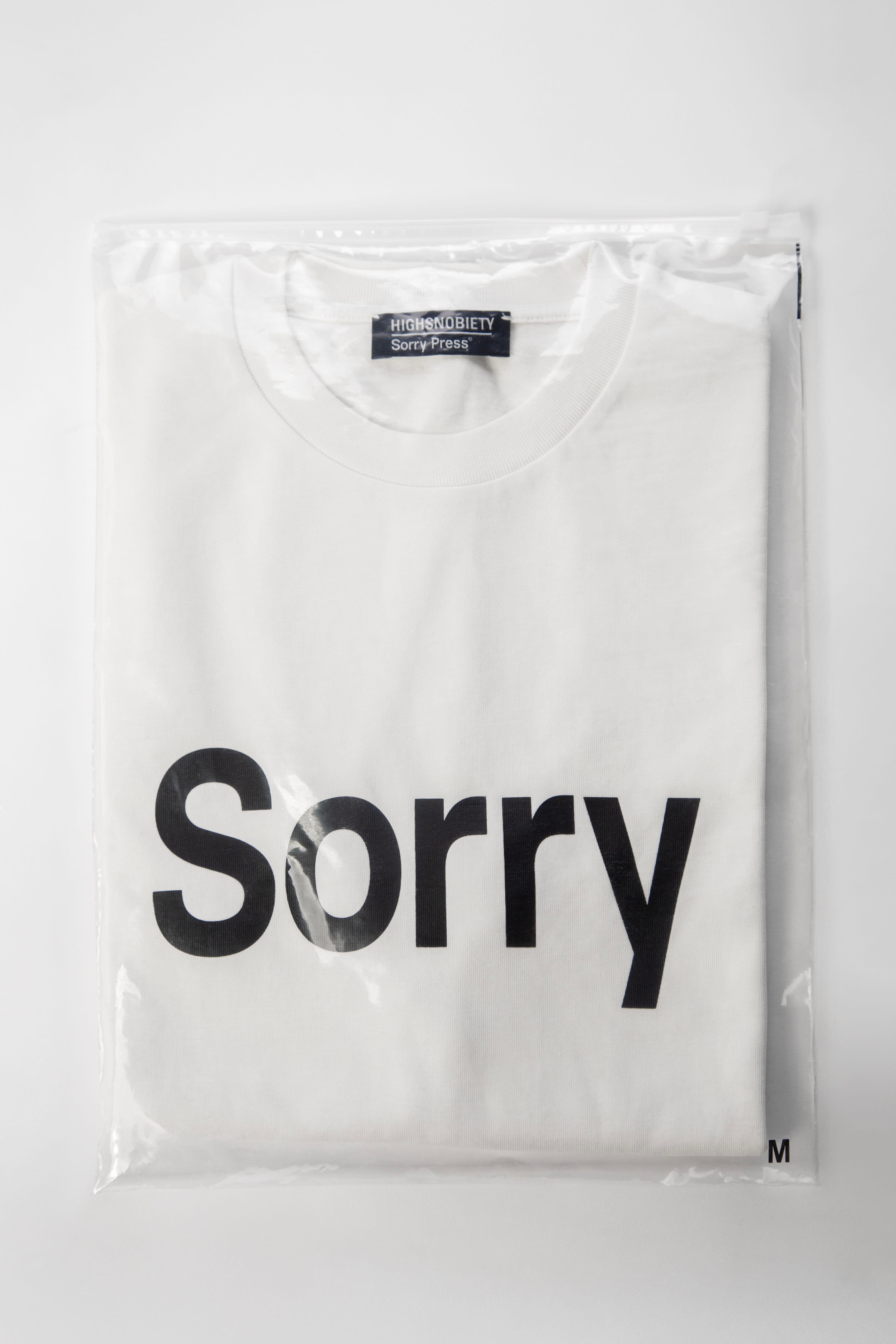 Folded white t-shirt with printed design "Sorry", packaged and ready for delivery.