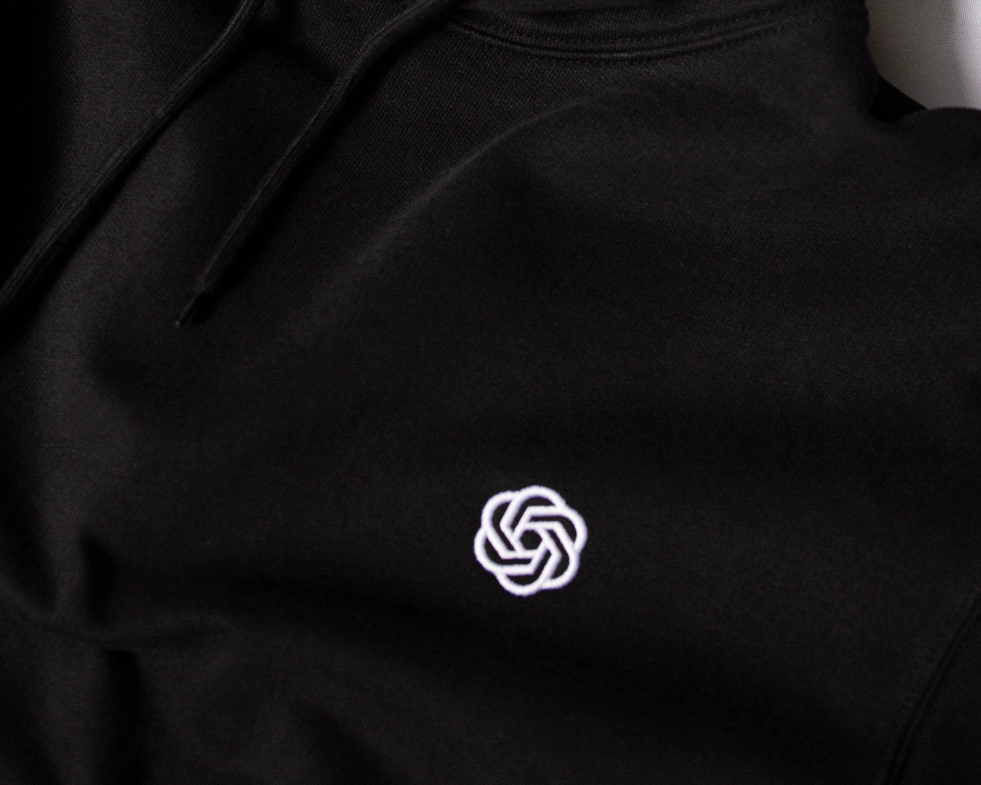 Black hoodie with "Thrive Capital" label inside the collar and a white geometric logo embroidered on the chest.