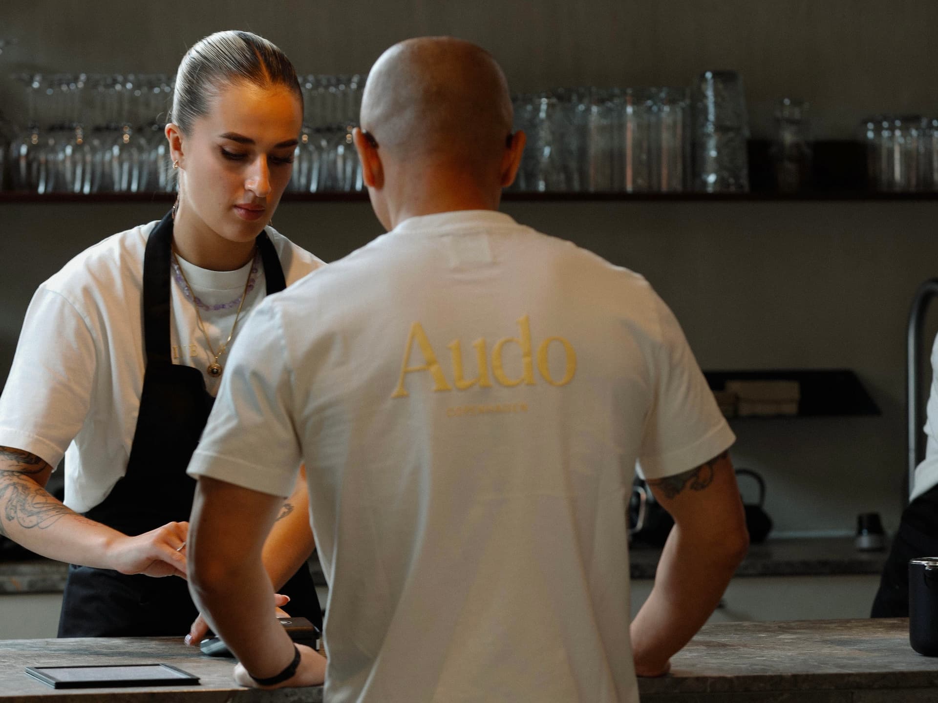 Restaurant staff at Audo wearing custom branded t-shirts, showing how uniforms can build brand identity and enhance guest experience