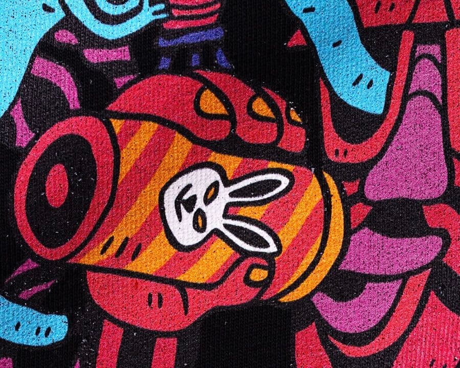 Colorful dtg graffiti featuring a stylized rabbit face on an orange and red striped background with abstract shapes in blue and pink.